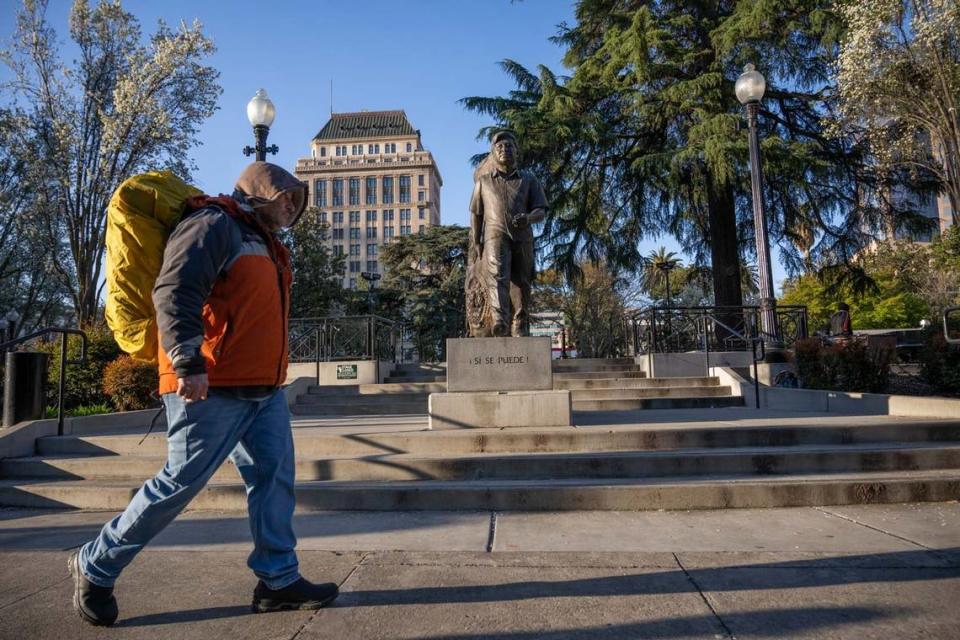 An homeless man walks past the Cesar Chavez monument Sunday at Cesar Chavez Plaza. Some downtown business leaders have a vision to improve the historic civic square in spite of many challenges.