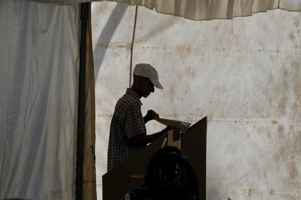 A voter marks his candidates on the ballot during general elections in Santo Domingo, Dominican Republic, Sunday, May 19, 2024. (AP Photo/Matias Delacroix)