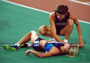 30 Sep 2000: Marla Runyan of the USA helps compatriot Suzy Favor Hamilton after the Womens 1500m Final at the Olympic Stadium on day 15 of the Sydney 2000 Olympic Games in Sydney, Australia. \ Mandatory Credit: Shaun Botterill /Allsport