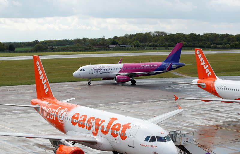 FILE PHOTO: A Wizz Air Airbus A320 passes easyJet planes after landing at Luton Airport