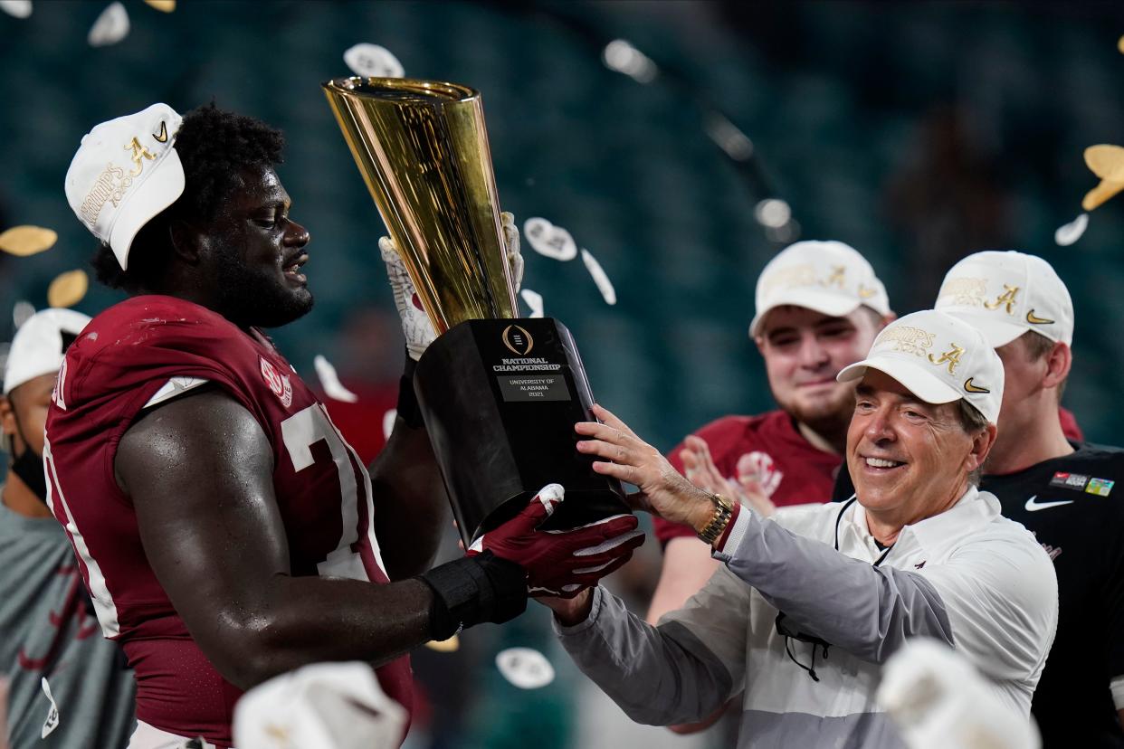 Alabama head coach Nick Saban and offensive lineman Alex Leatherwood hold the national championship trophy after the Crimson Tide defeated Ohio State Jan. 12, 2021, in Miami Gardens, Florida.