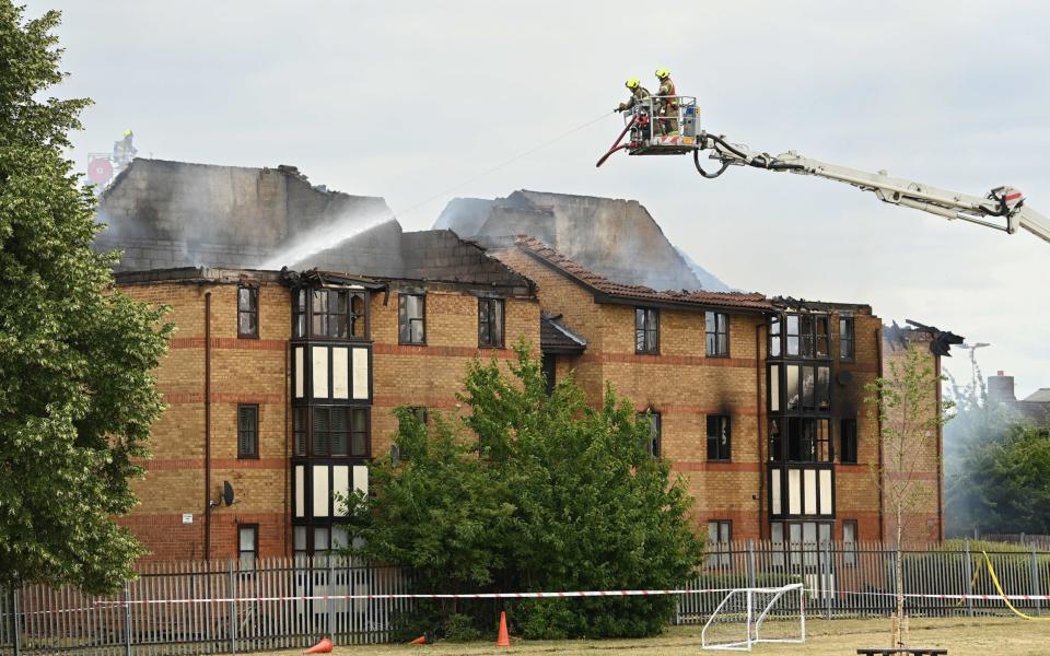 Firefighters at the scene of a gas blast in Redwood Grove, Bedford, where two people were injured, one seriously, after the explosion caused an "inferno" at a block of flats. - Doug Peters/PA Wire