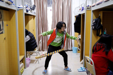 Peng Jianghua, a student majoring in esports and management, plays with a hula hoop in her dormitory room at the Sichuan Film and Television University in Chengdu, Sichuan province, China, November 19, 2017.REUTERS/Tyrone Siu