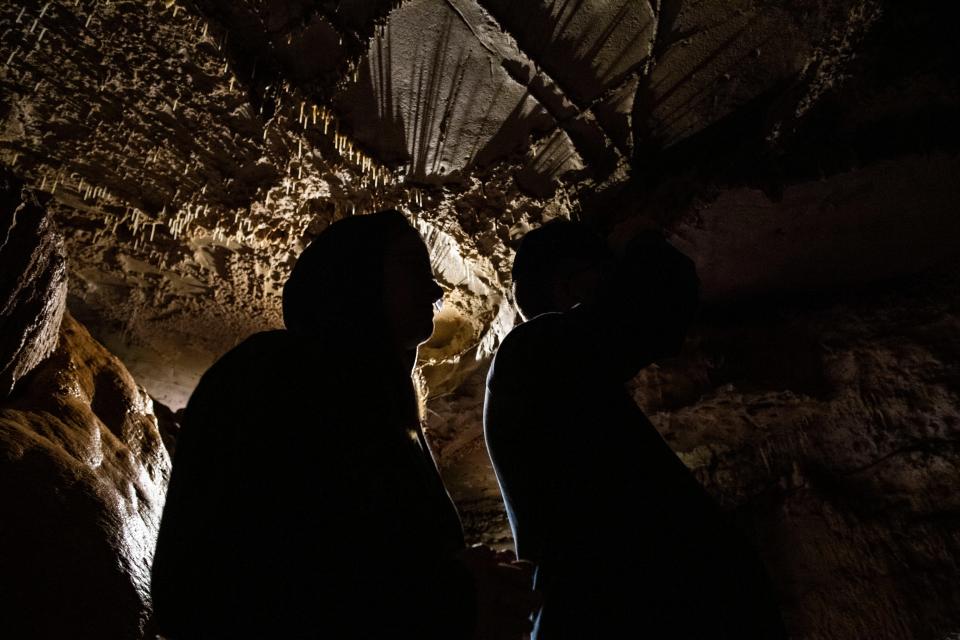 Jesse Hoogenboom and Del Hoogenboom, of Canada, listen during a tour given by Amelia Hurt inside the Bell Witch Cave in Adams, Tenn., Thursday, Oct. 5, 2023.