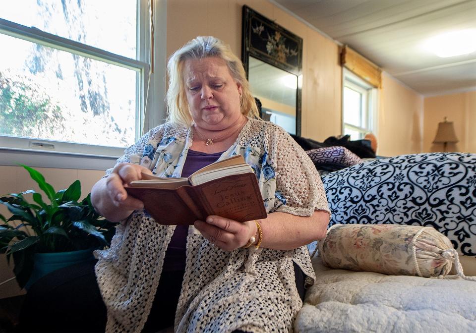 Karen McDonald, of Falls Township, takes time out each day in reading a Daily Devotion from the book, "Jesus Calling." She sits in her new mobile home, which she moved into this fall after months searching for housing that would accept her federal voucher.