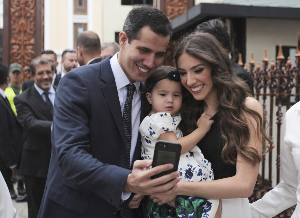 FILE - In this Jan. 5, 2019 file photo, incoming congressional president Juan Guaido, left, takes a selfie photo with his wife Fabiana Rosales and his daughter Miranda Guaido upon arrival to swear in the new board of the National Assembly in Caracas, Venezuela. Guaido stunned Venezuelans on Wednesday, Jan. 23, 2019 by declaring himself interim president before cheering supporters in Venezuela’s capital, buoyed by massive anti-government protests. (AP Photo/Fernando Llano, File)