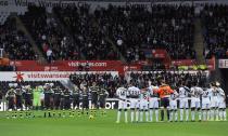 Swansea City (R) and Stoke City stand for a minute of silence before their English Premier League soccer match at the Liberty Stadium in Swansea, Wales, November 10, 2013.