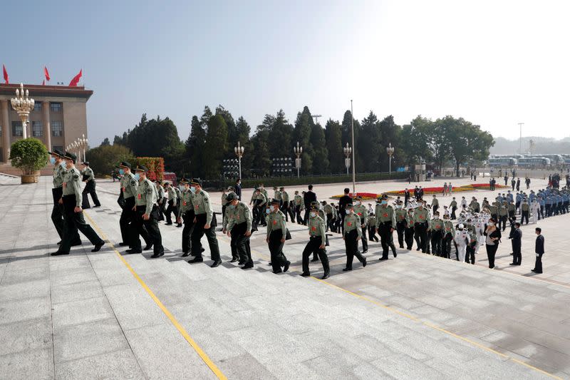 Military delegates wearing face masks following the coronavirus disease (COVID-19) outbreak, arrive to the Great Hall of the People before the opening session of the National People's Congress (NPC) in Beijing