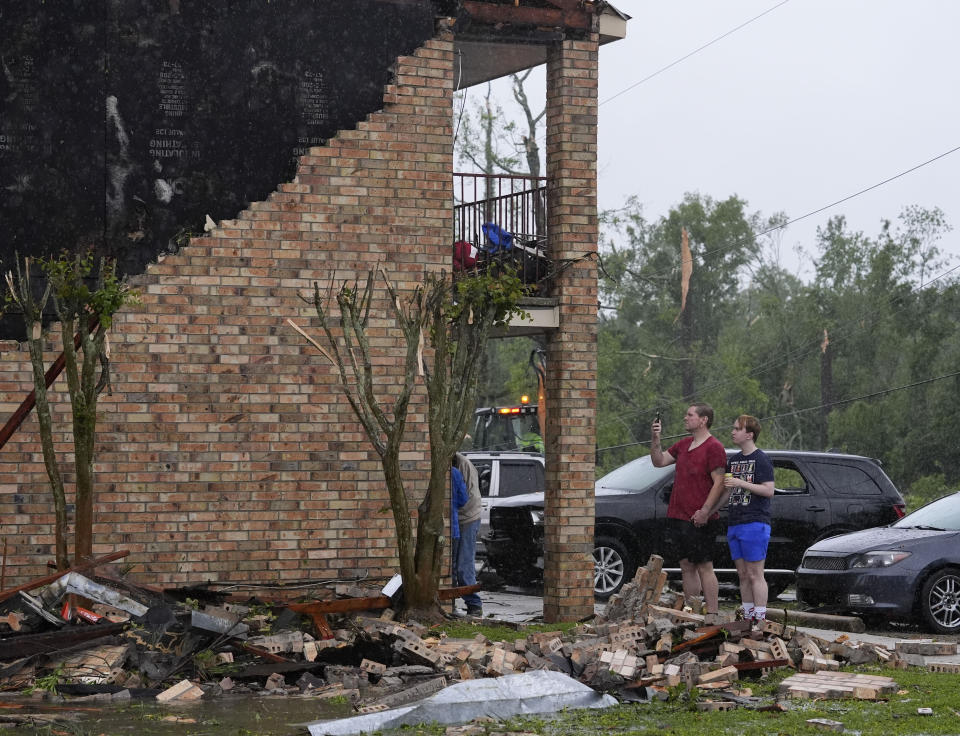 Residents of a heavily damaged apartment complex survey the damage in the aftermath of severe storms that swept through the region in Slidell, La., Wednesday, April 10, 2024. (AP Photo/Gerald Herbert)