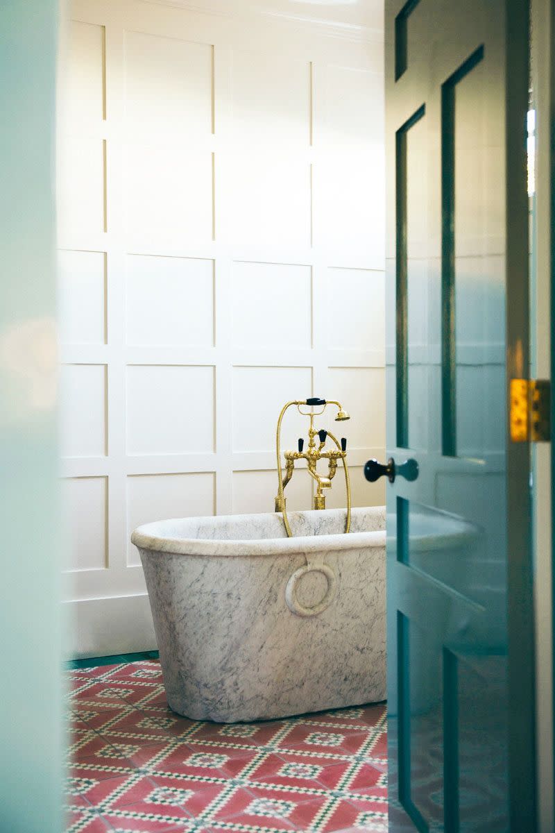 <p>Though the striking freestanding marble tub with Victorian, old-school fixtures is the clear focal point of this bathroom by <a href="https://annaspirodesign.com.au/projects/" rel="nofollow noopener" target="_blank" data-ylk="slk:Anna Spiro Design;elm:context_link;itc:0;sec:content-canvas" class="link ">Anna Spiro Design</a>, the tile floors set the foundation for the entire space (plus, their worn finish and playful design make it feel more approachable and historic).</p>