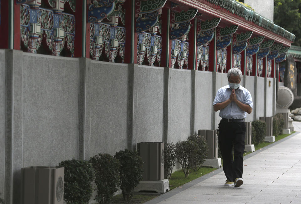 A Taiwanese man prays and detours outside of Longshan Temple after the COVID-19 alert raise to level 3 in Taipei, Taiwan, Tuesday, May 18, 2021. (AP Photo/Chiang Ying-ying)