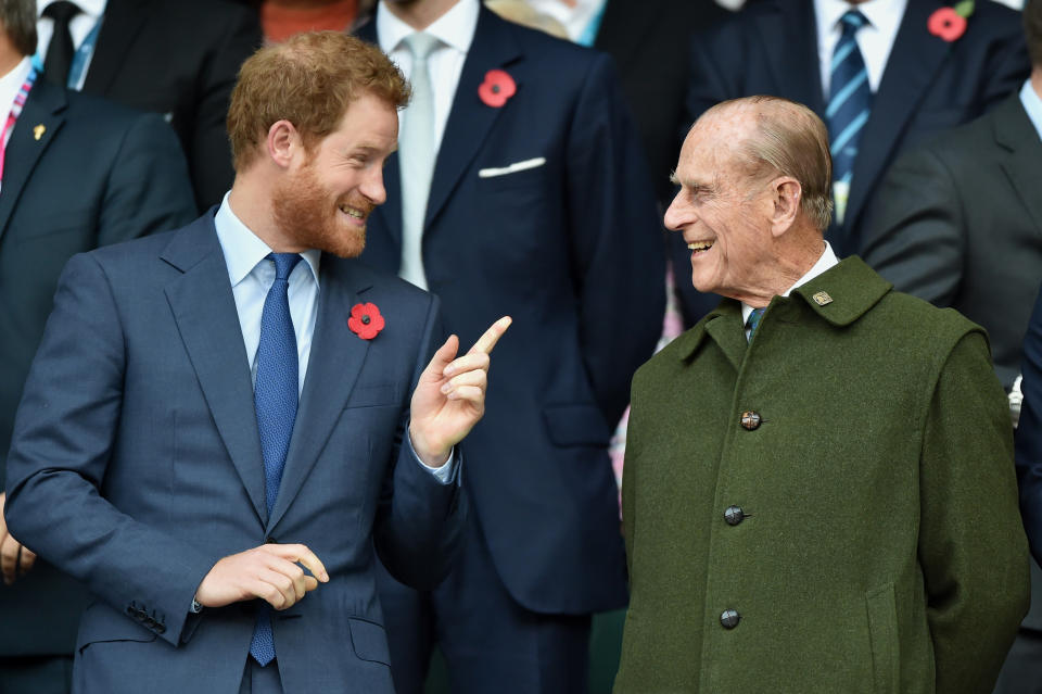 Prince Harry and Prince Philip, Duke of Edinburgh share a joke at the 2015 Rugby World Cup Final match between New Zealand and Australia at Twickenham Stadium on October 31, 2015 in London, England