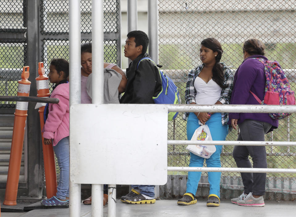 FILE- In this Saturday, Nov. 3, 2018, file photo immigrants seeking asylum in the United States wait on the the International Bridge in Reynosa, Mexico. Asylum seekers already camping at border crossings worry that how the Trump administration responds to the caravan of some 4,000 Central American migrants and three much smaller ones hundreds of miles behind it could leave them shut out. (AP Photo/Eric Gay, File)