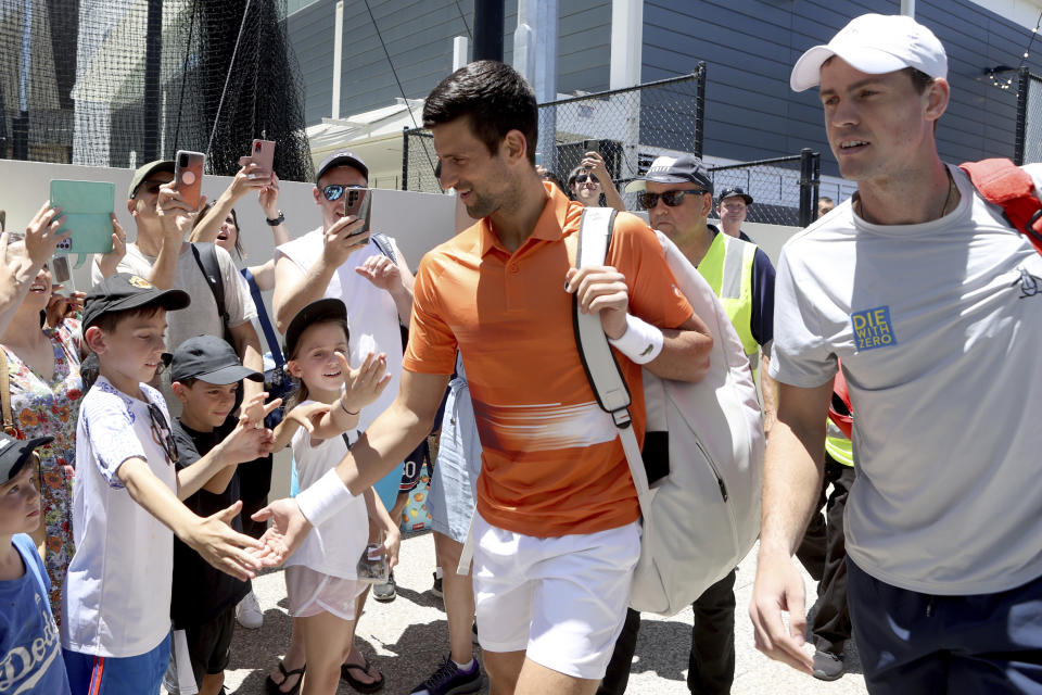 Serbia's Novak Djokovic (right) and Canada's Vasek Pospisil with fans before his doubles match during their Round of 32 match at the Adelaide International Tennis tournament in Adelaide, Australia, Monday, Jan. 2, 2023. (AP Photo/Kelly Barnes)