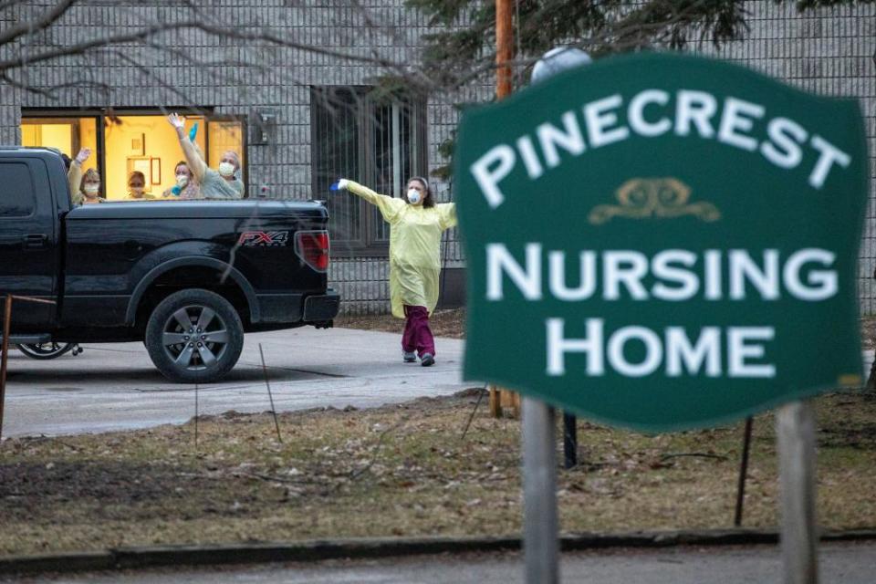 Staff at the Pinecrest nursing home in Bobcaygeon, Canada, wave to passing cars sounding their horns in support after 29 residents died and dozens of staff were made ill by coronavirus.