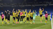 Dortmund players celebrate at the end of the German Bundesliga soccer match between FC Schalke 04 and Borussia Dortmund in Gelsenkirchen, Germany, Saturday, Feb. 20, 2021. Dortmund won 4-0. (AP Photo/Martin Meissner, Pool)