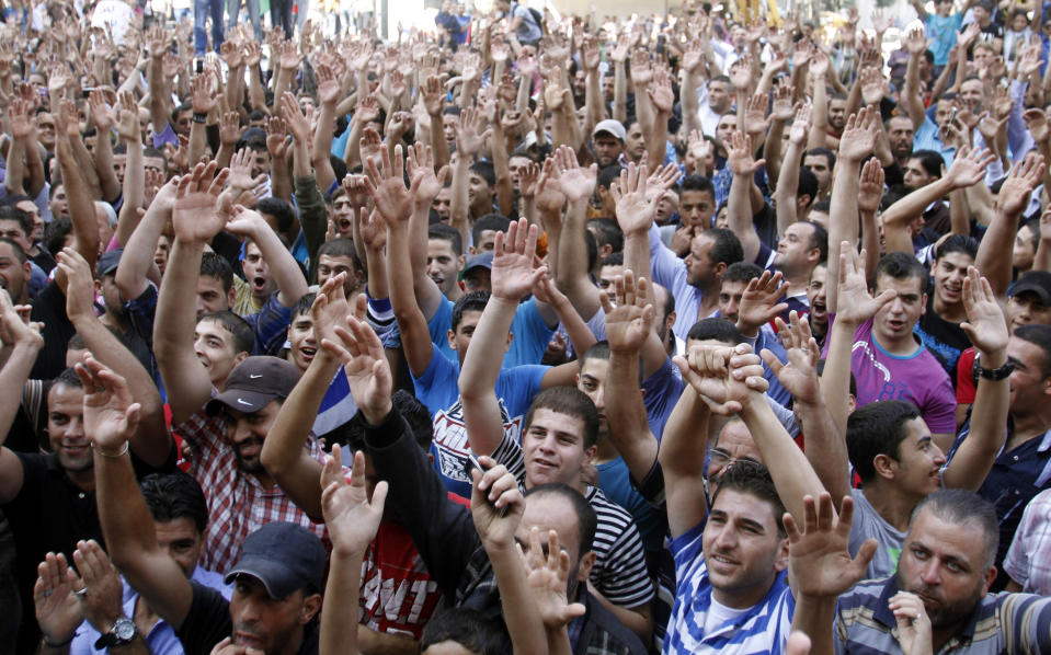 Palestinians chant slogans against Palestinian Prime Minister Salam Fayyad during a protest against the high cost of living in the West Bank city of Hebron, Monday, Sept. 10, 2012. Palestinian demonstrators fed up with high prices and unpaid salaries shuttered shops, halted traffic with burning tires and closed schools throughout the West Bank on Monday in the largest show of popular discontent with the governing Palestinian Authority in its 18-year history. (AP Photo/Nasser Shiyoukhi)