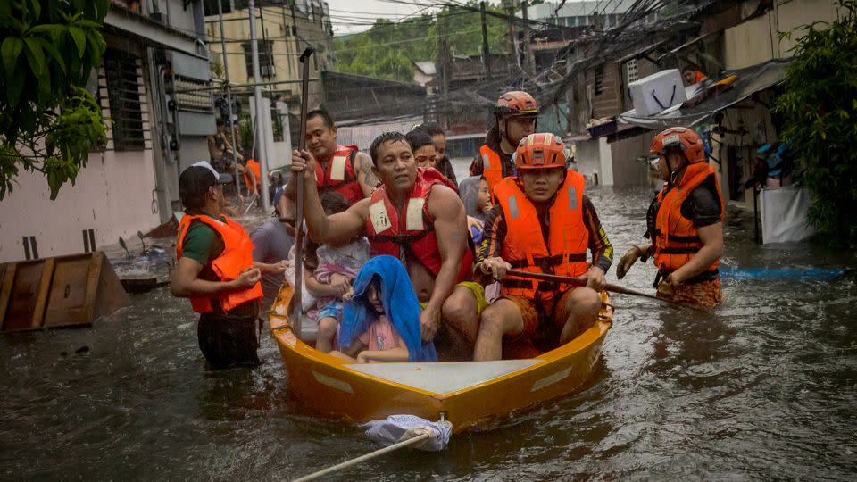 Rescuers evacuate residents from their flooded homes on July 24, 2024 in Quezon City. - Ezra Acayan/Getty Images