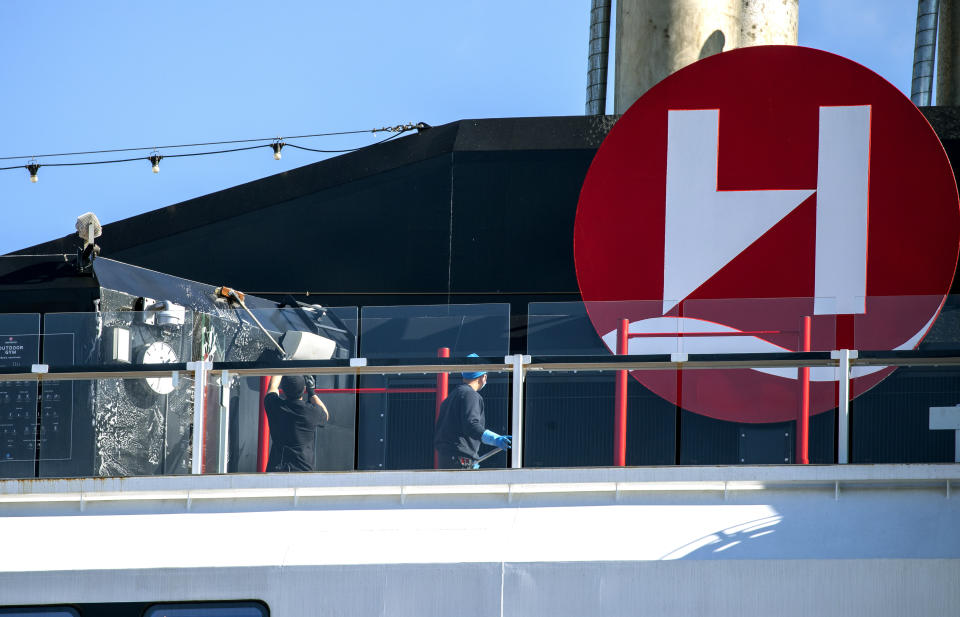 Crew members clean on board Hurtigruten's vessel MS Roald Amundsen, docked in Tromso, Norway, Sunday, Aug. 2, 2020. Over 30 crew members and an unconfirmed number of passengers have so far tested positive for the coronavirus after two international cruises which resumed operation recently, since the outbreak of the coronavirus pandemic. (Terje Pedersen/NTB scanpix via AP)