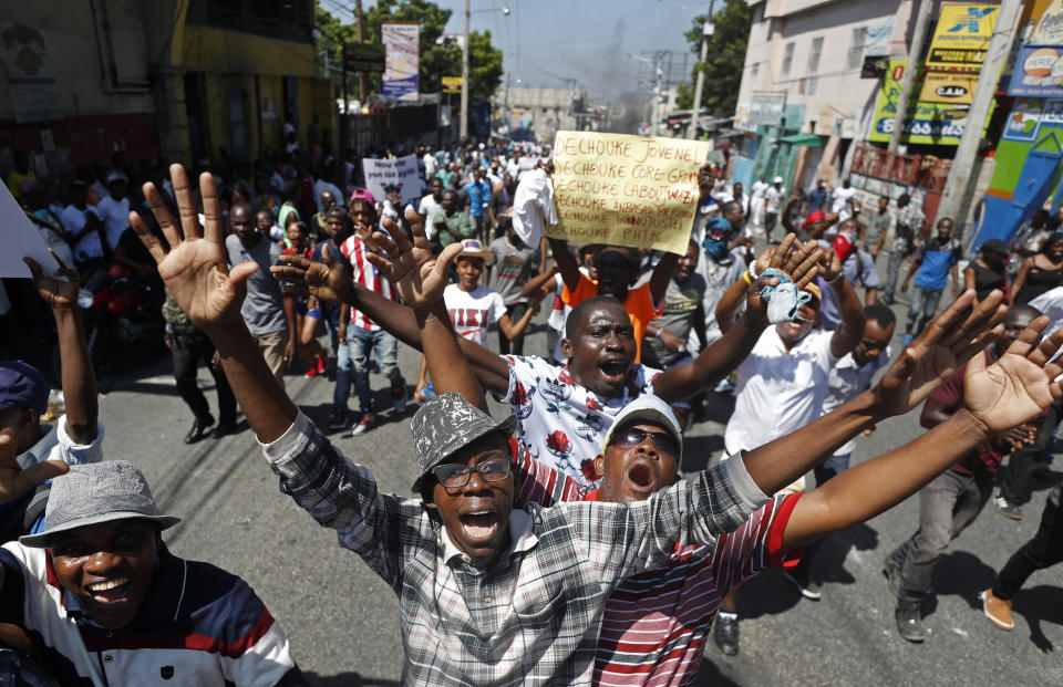 Protesters demand the resignation of Haitian President Jovenel Moise during a march led by the art community in Port-au-Prince, Haiti, Sunday, Oct. 13, 2019. Protests have paralyzed the country for nearly a month, shuttering businesses and schools. (AP Photo/Rebecca Blackwell)