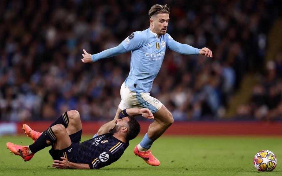 Manchester City's Jack Grealish challenges Real Madrid's Daniel Carvajal during the UEFA Champions League quarter final match between Manchester City and Real Madrid CF at the Etihad Stadium on April 17, 2024 in Manchester, England