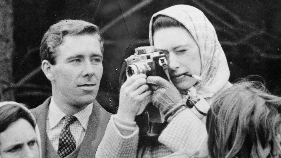 Professional photographer Antony Armstrong-Jones, the Earl of Snowdon, watches critically as his fiancee Princess Margaret (1930 - 2002) takes a snap at the Badminton Horse Trials