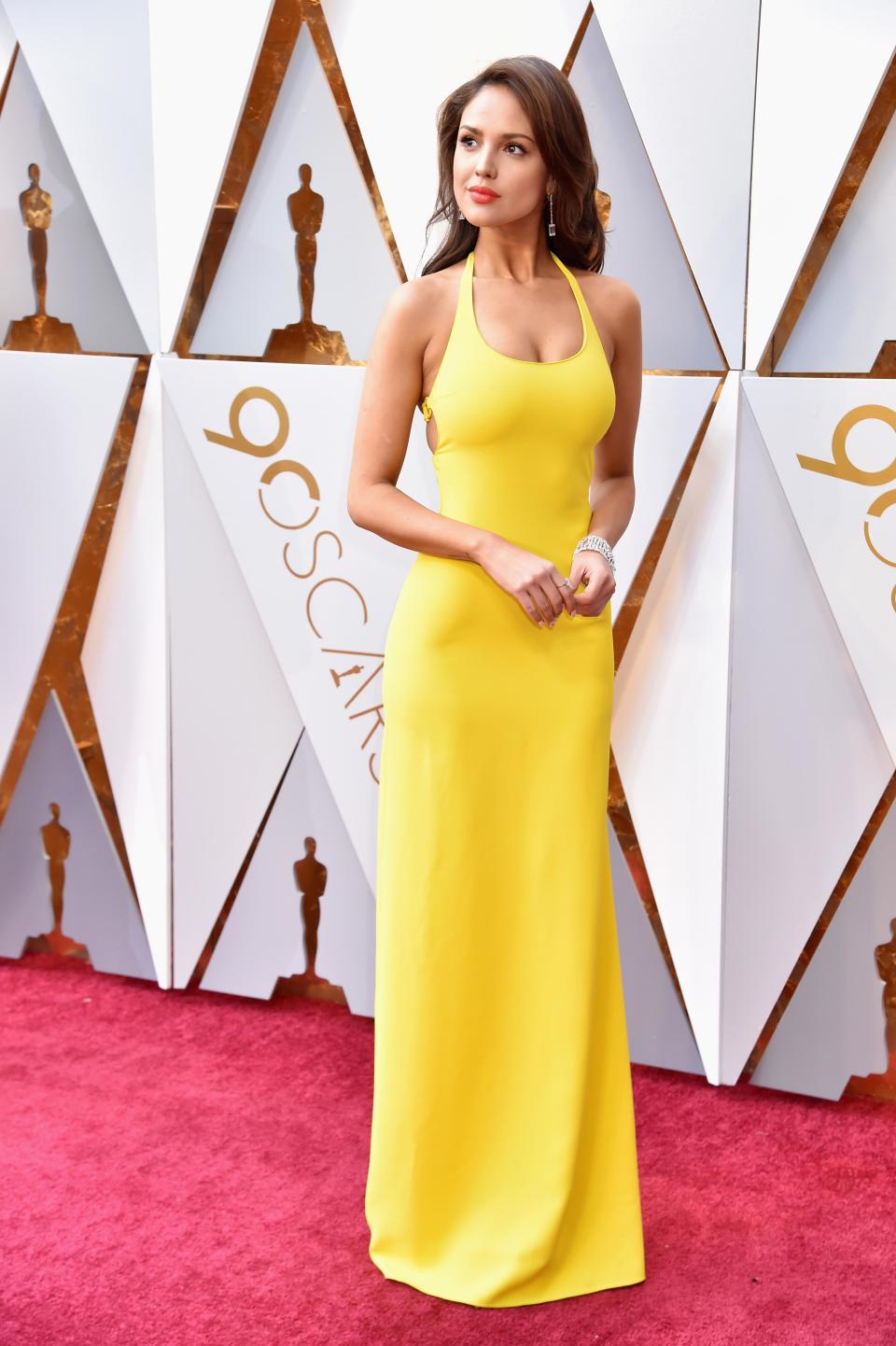 <p>Eliza Gonzales stuns in a bright yellow body-con dress designed by Ralph Lauren.</p>