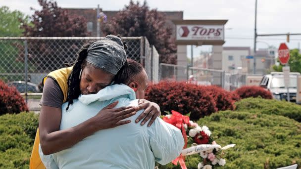 PHOTO: People embrace near a memorial for the shooting victims outside of Tops grocery store on May 20, 2022 in Buffalo, N.Y. 18-year-old Payton Gendron is accused of the mass shooting that killed 10 people at the Tops grocery store on May 14th. (Spencer Platt/Getty Images)