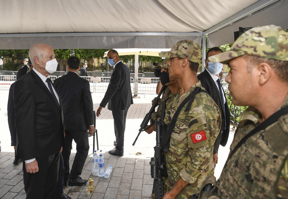 Tunisian President Kais Saied talks to soldier as he stroll along the avenue Bourguiba in Tunis, Tunisia, Sunday, Aug. 1, 2021. President Kais Saied claimed on Sunday that some desperate youth are being paid to try to leave Tunisia illegally for Europe, saying the goal is to damage the country from within. (Slim Abid/Tunisian Presidency via AP)