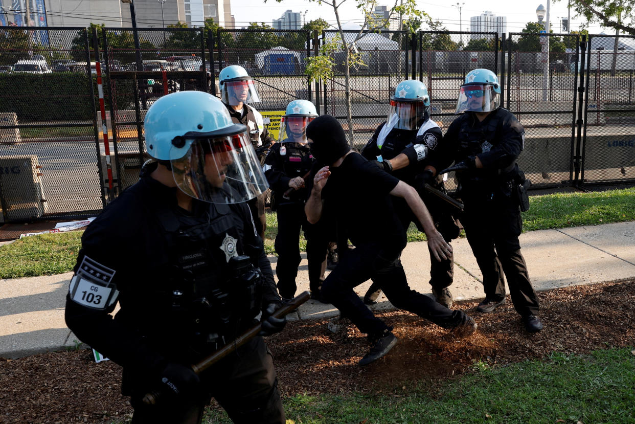 Police officers in riot gear hold a demonstrator during a protest outside the Democratic National Convention in Chicago Monday. 