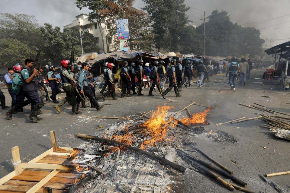 Police officers conduct a raid in an area after clashes with Jamaat-e-Islami party activists in Dhaka