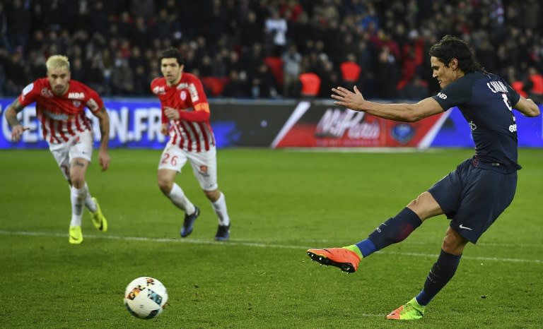 Paris Saint-Germain's forward Edinson Cavani (R) kicks the ball before scoring during the French L1 football match against Nancy March 4, 2017