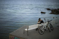 A couple sit on a bench in Odesa, Ukraine, Tuesday, May 17, 2022. (AP Photo/Francisco Seco)