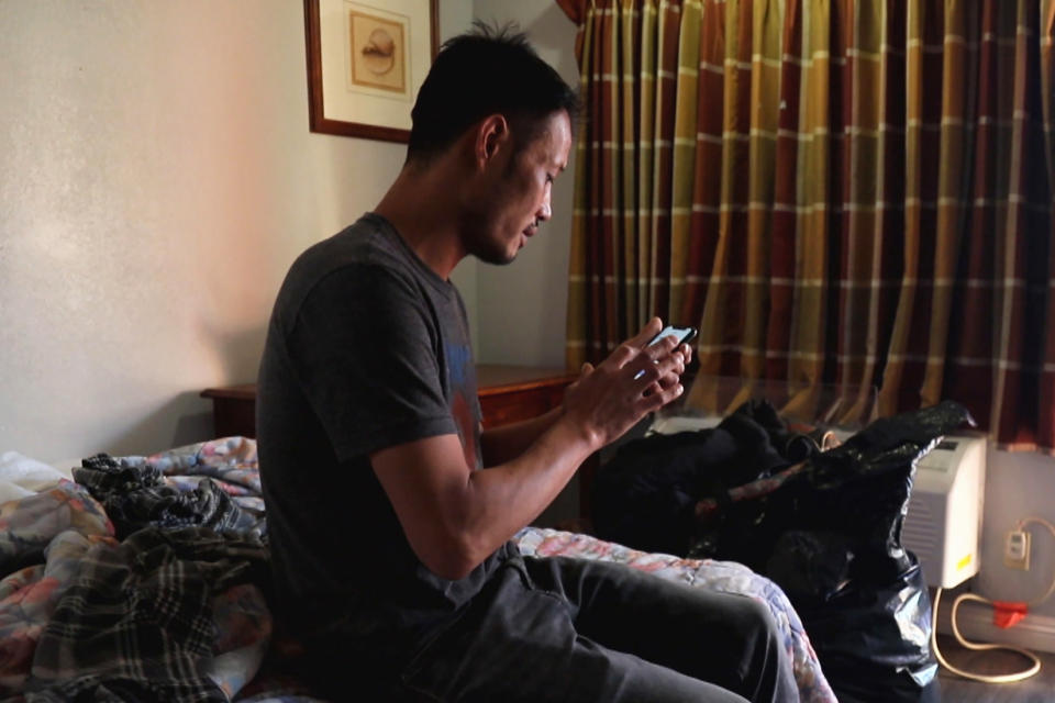 Jin uses a cellphone in his motel room. (NBC News)