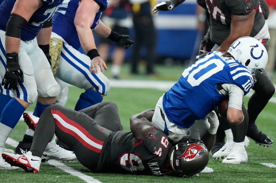 Indianapolis Colts quarterback Gardner Minshew (10) is sacked by Tampa Bay Buccaneers defensive tackle Calijah Kancey (94) during the second half of an NFL football game Sunday, Nov. 26, 2023, in Indianapolis. (AP Photo/Darron Cummings)