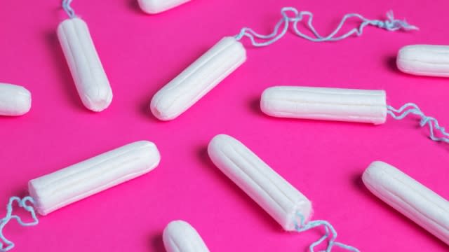 Unused cotton tampons on a pink background
