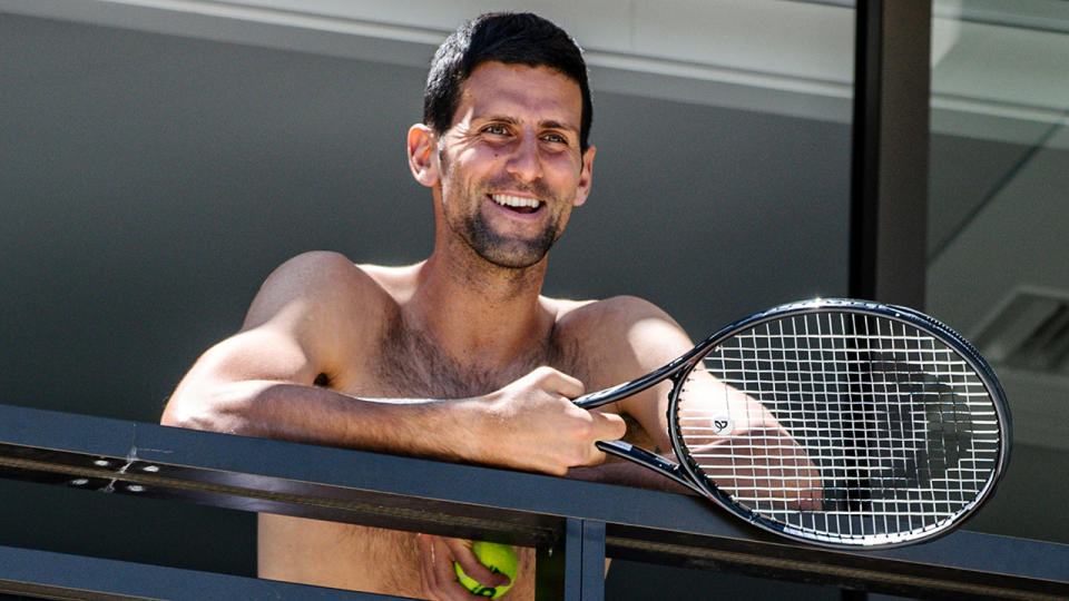 Novak Djokovic smiles at fans from a hotel balcony in Adelaide, South Australia on January 20, 2021, one of the locations where players have quarantined for two weeks upon their arrival ahead of the Australian Open. (Photo by MORGAN SETTE/AFP via Getty Images)