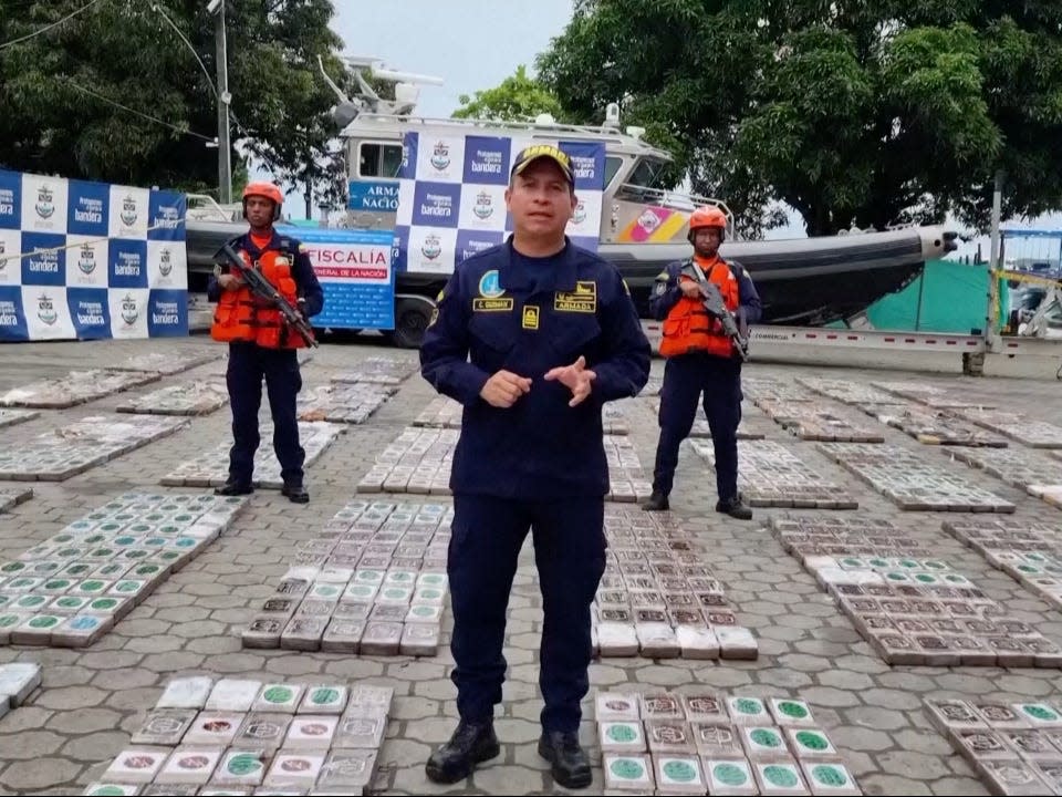 Frigate Captain Cristian Andrés Guzmán, commander of the anti-narcotics task force, stands among the cocaine packets lying on the ground.