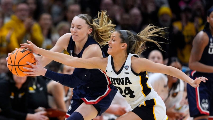 UConn guard Paige Bueckers, left, fights for a loose ball with Iowa guard <a class="link " href="https://sports.yahoo.com/ncaaw/players/60994/" data-i13n="sec:content-canvas;subsec:anchor_text;elm:context_link" data-ylk="slk:Gabbie Marshall;sec:content-canvas;subsec:anchor_text;elm:context_link;itc:0">Gabbie Marshall</a> (24) during the first half of a Final Four college basketball game in the women’s NCAA Tournament, Friday, April 5, 2024, in Cleveland. (AP Photo/Carolyn Kaster)