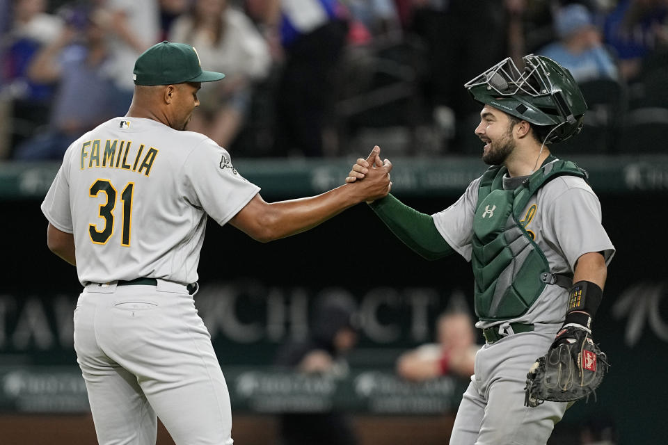 Oakland Athletics' Jeurys Familia (31) and Shea Langeliers celebrate the team's win in a baseball game against the Texas Rangers, Friday, April 21, 2023, in Arlington, Texas. (AP Photo/Tony Gutierrez)