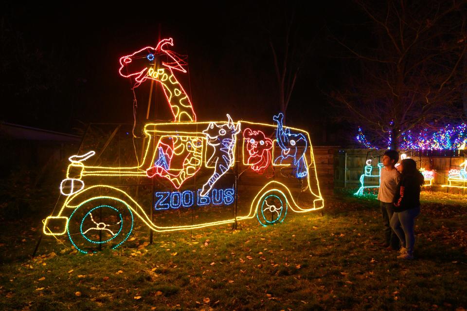 Bell Montoya (right) and Damian De La Riva look over the Zoo Bus filled with animals during the 2019 opening night of the Pueblo Zoo's ElectriCritters.