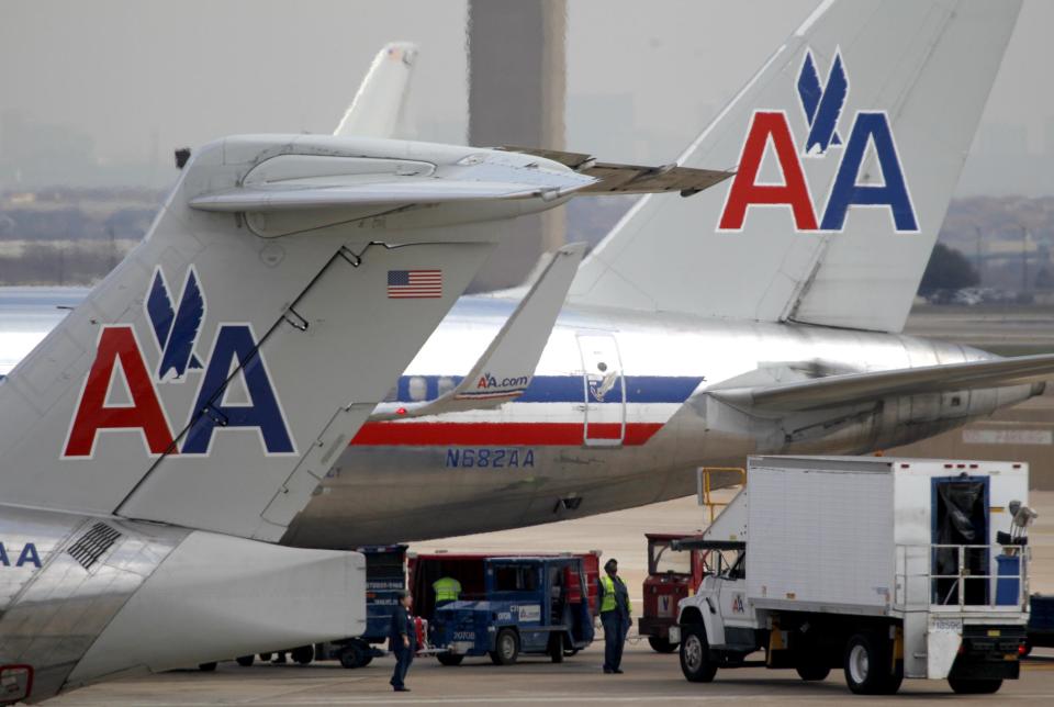 An American Airlines ground crew work an aircraft before departure at Dallas-Fort Worth International airport in Grapevine, Texas, Wednesday, Feb. 1, 2012. American Airline corporate leadership is having closed door meetings with union representatives about the future of jobs and the pension for workers. (AP Photo/LM Otero)