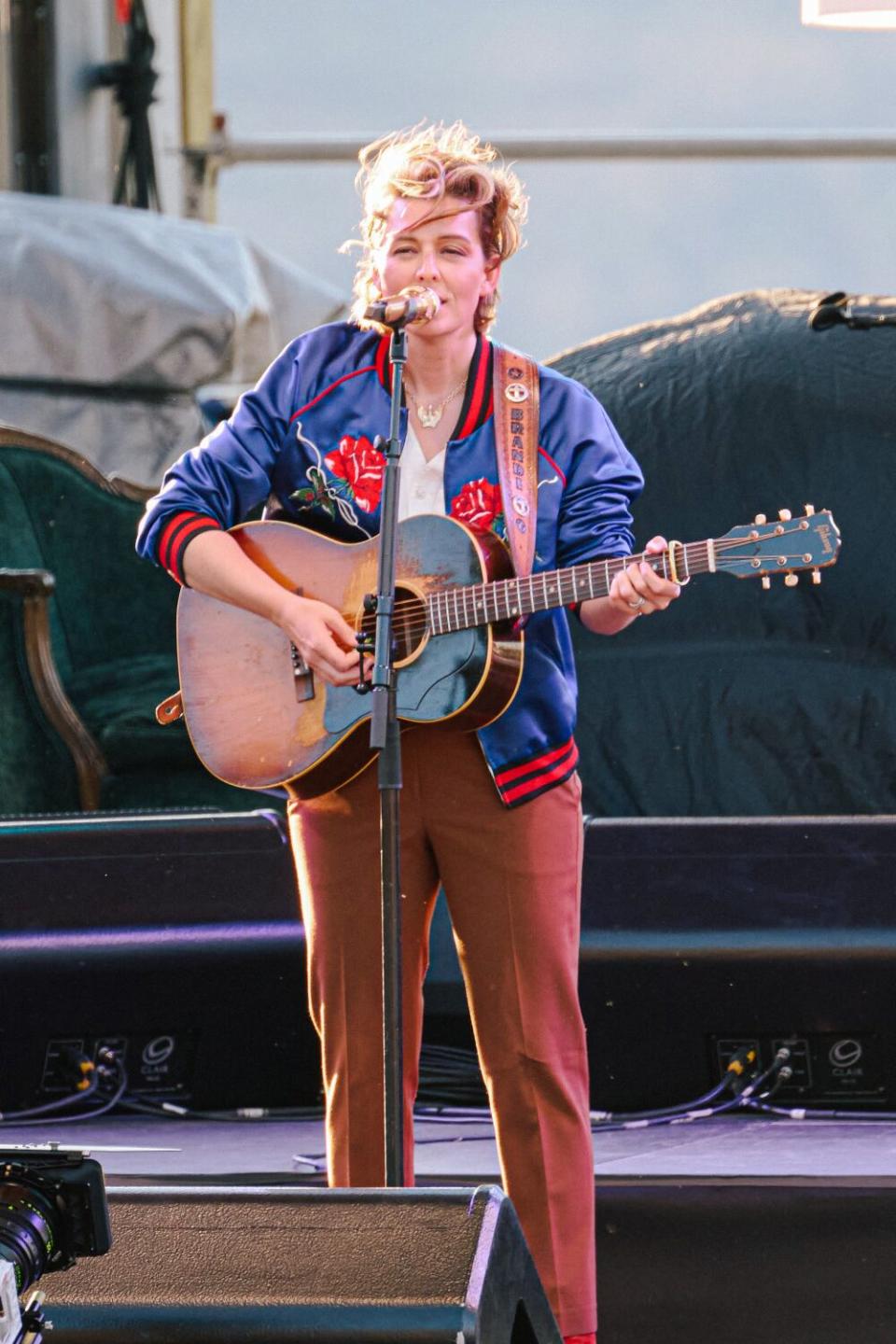 Brandi Carlile plays a guitar and sings onstage