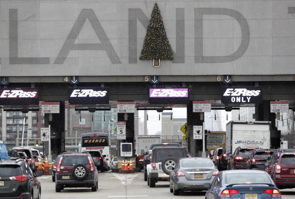 A Christmas tree adorns one of the letters on the toll booth structure on the Holland Tunnel approach, Thursday, Dec. 13, 2018, in Jersey City. Motorists are complaining that two circular wreaths and another in the shape of a Christmas tree, symmetrically aligned above the tunnel's lanes, don't look right. An online petition suggests placing the tree over the letter "A" instead of the "N". (AP Photo/Julio Cortez)