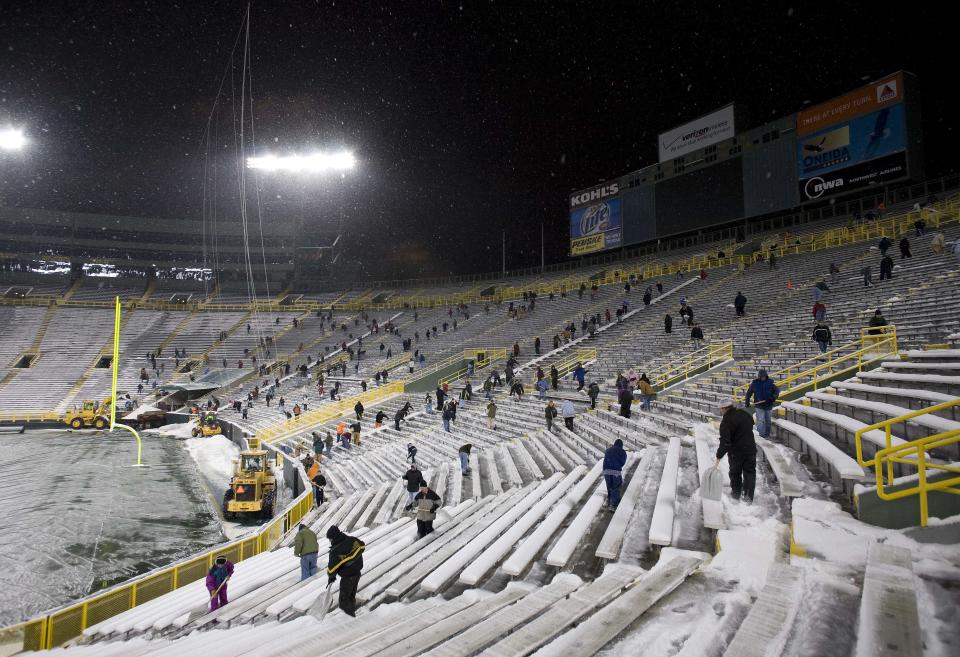 Hundreds of people shovel snow from the seating sections  at Lambeau Field as snow falls Thursday, Jan. 17, 2008, in Green Bay, Wis. The Green Bay Packers face the New York Giants in the NFC Championship football game Sunday, Jan. 20, 2008, at Lambeau Field. (AP Photo/Morry Gash)