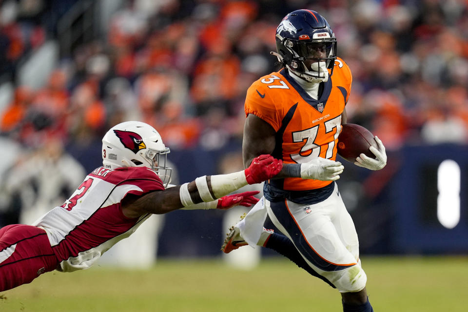 Denver Broncos running back Marlon Mack (37) eludes the reach of Arizona Cardinals safety Budda Baker during the second half of an NFL football game, Sunday, Dec. 18, 2022, in Denver. (AP Photo/Jack Dempsey)