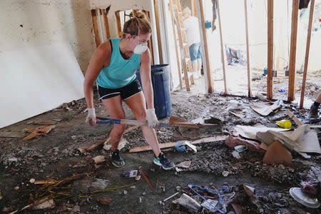 People clean up their house that was destroyed following Hurricane Michael in Mexico Beach, Florida, U.S., October 13, 2018. REUTERS/Carlo Allegri