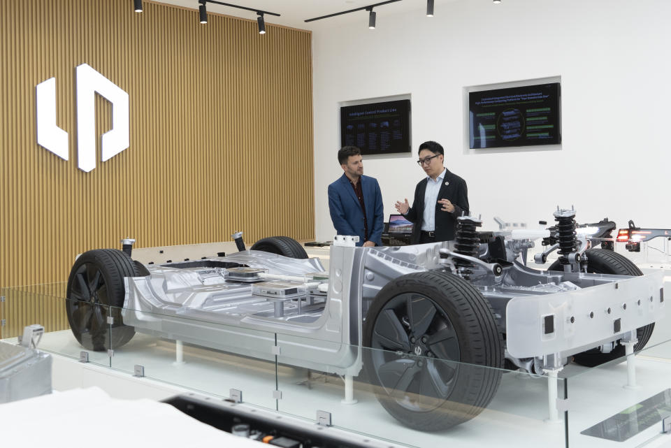 Visitors look at a cutaway of a Leapmotor vehicle at the company showroom in Hangzhou in eastern China's Zhejiang province on Tuesday, May 14, 2024. European carmaker Stellantis on Tuesday said it had formed a joint venture with the Chinese electric vehicle startup Leapmotor that will begin selling EVs in nine European countries later this year. (AP Photo/Caroline Chen)