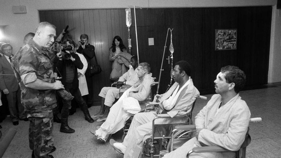 In this Oct. 25, 1983, file photo, U.S. Marine Corps Commandant Paul Kelley, left, awarded the Purple Heart to Marines wounded in the terrorist bombing in Beirut during a ceremony at the Wiesbaden Air Force hospital, in Germany. At right (from back to front) Renard Manley. Michael Balcon, Elvin H. Henry and Pedro J. Alvaredo. (Udo Weitz, File/The Associated Press)