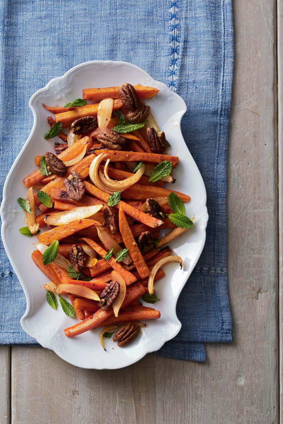 <p>Coated in orange juice, spices, and olive oil, this sweet potato, carrot, and onion mix pops with flavor.</p><p><a href="https://www.womansday.com/food-recipes/food-drinks/recipes/a39378/roasted-sweet-potatoes-carrots-recipe-clx1113/" rel="nofollow noopener" target="_blank" data-ylk="slk:Get the Roasted Sweet Potatoes and Carrots recipe.;elm:context_link;itc:0;sec:content-canvas" class="link "><em><strong>Get the Roasted Sweet Potatoes and Carrots recipe.</strong></em></a> </p>